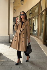 a lady in a brown trench coat and a pair of black pants
